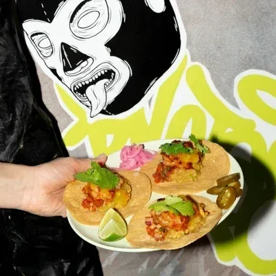 Tacos podane w Margariteros na tle ściany z ilustracją